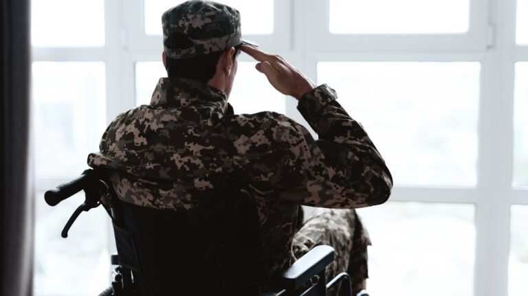 man in military uniform sits in a wheelchair