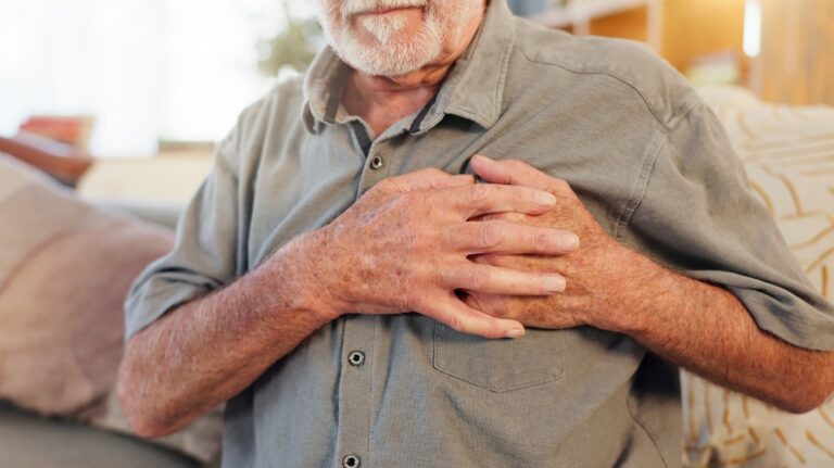 senior man hands on chest for heart pain